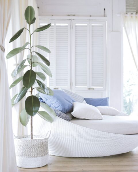 White interiors in a luxury home showing a white wicker daybed